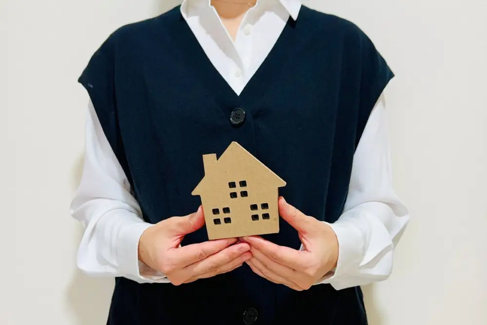 女性が家の模型を持つ